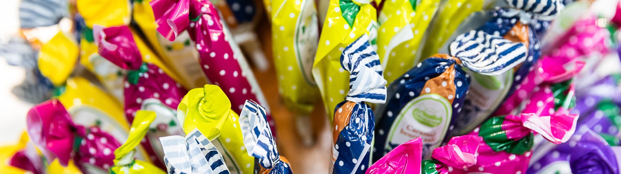 Candies wrapped in colorful polka-dot papers, arranged in a bouquet-style display.
