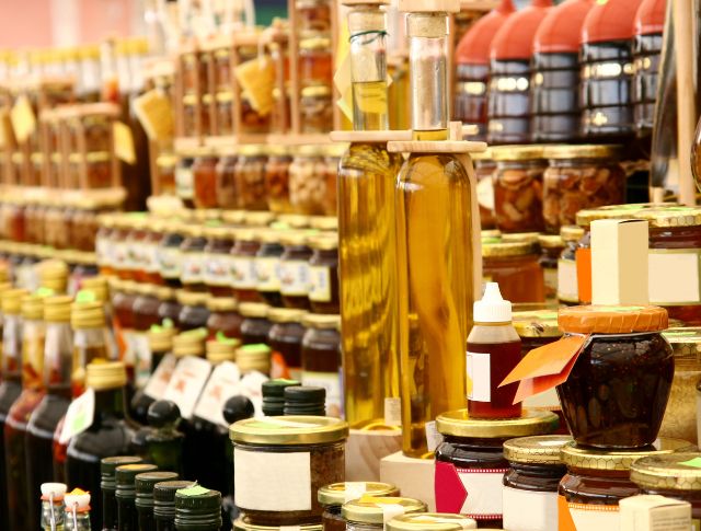 Plateau de Rayons d’un marché de produits fins avec des bouteilles d’huile, des bocaux de confitures et de conserves artisanales.françaises variées : croissants, roulés aux raisins, torsades au chocolat.