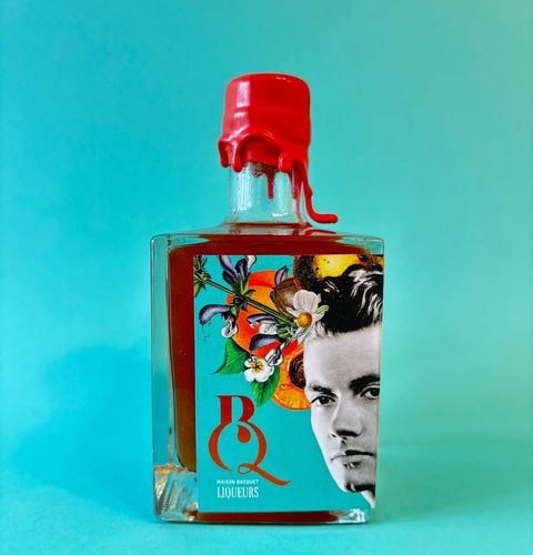 Liqueur bottle with melting red wax and illustrated label, displayed on a turquoise background.