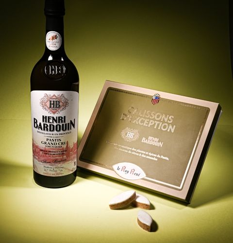 Bouteille Henri Bardouin et coffret de calissons de réception, présentés sur fond vert lumineux.