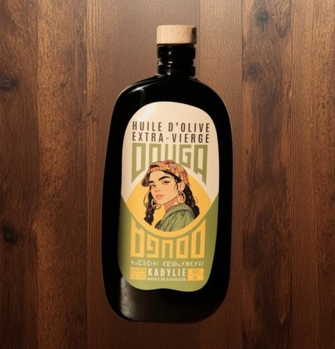 Black bottle of extra virgin olive oil from Kabylie, with illustrated label on wooden background.