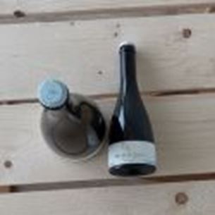 Deux bouteilles de vin posées sur une table en bois clair, photographiées en vue plongeante.